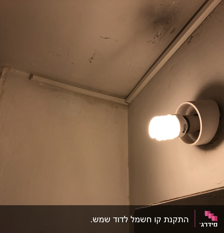 נורה דולקת על קיר עם חוטי חשמל